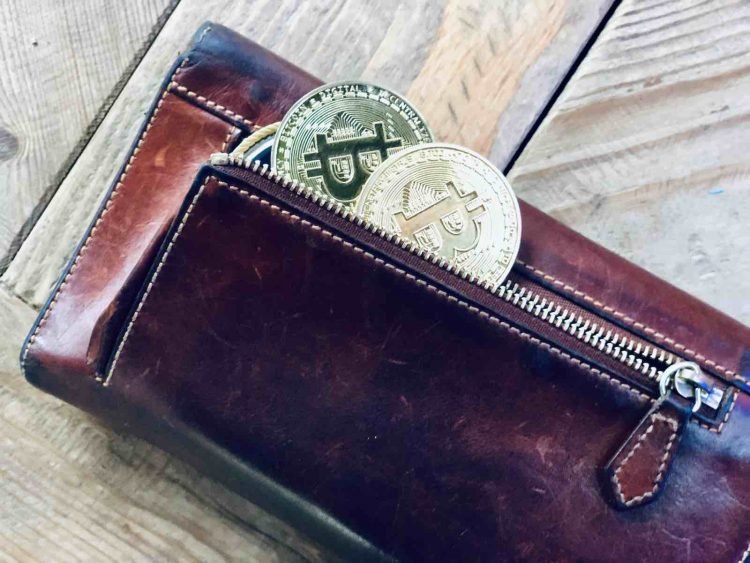 a wallet filled with physical bitcoin