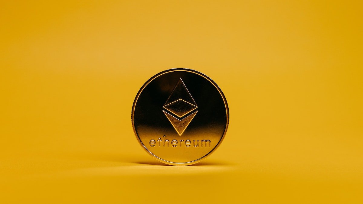 A physical Ethereum Token on a yellow background